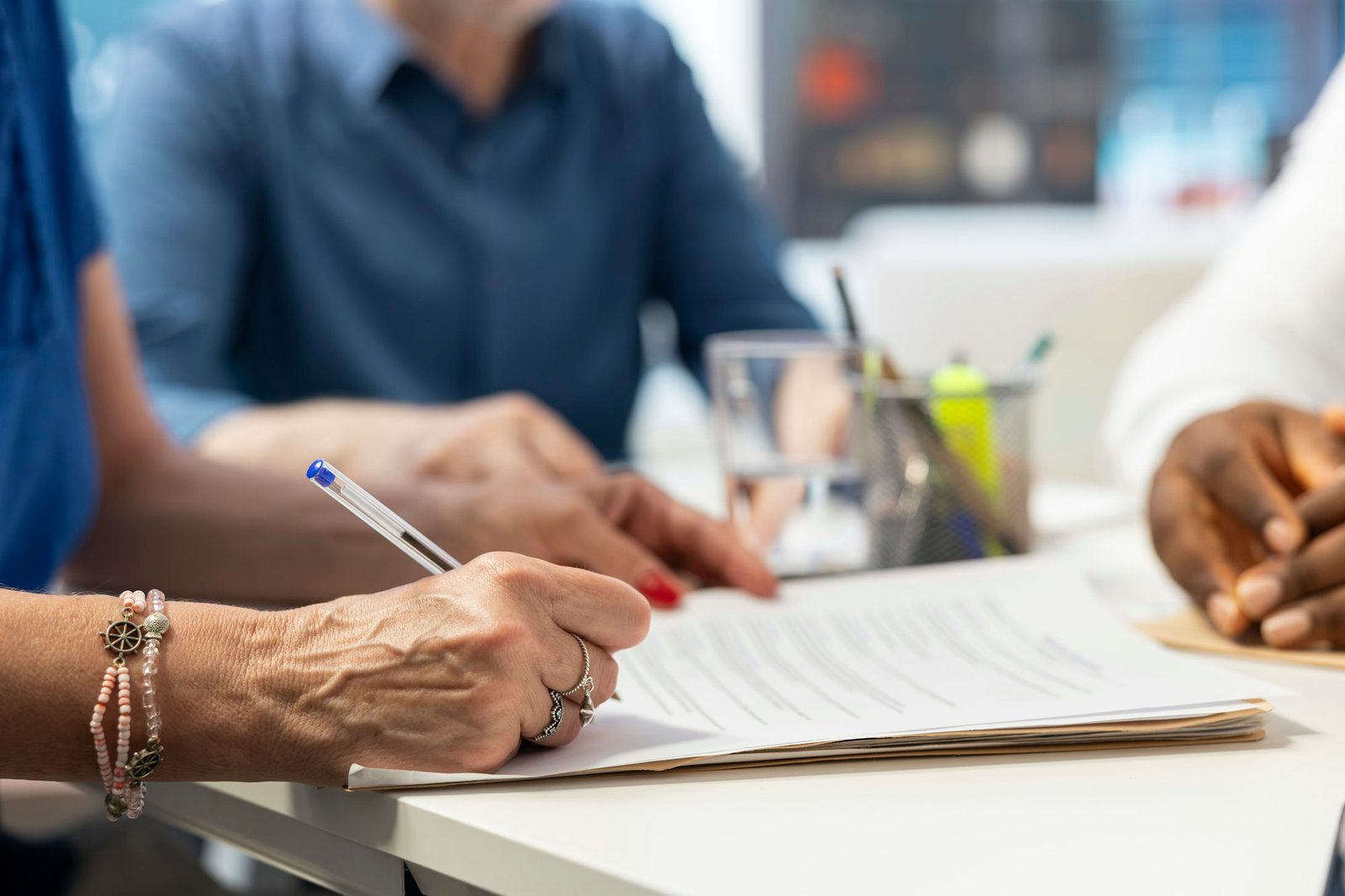 Senior client signing pension plan contract to ensure life insurance policy